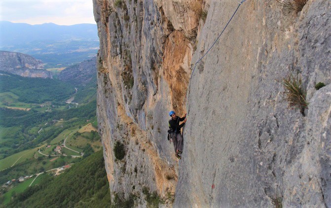 Un homme escalade une falaise en dalle à Preles. Une très belle Destination pour se perfectionner en escalade.