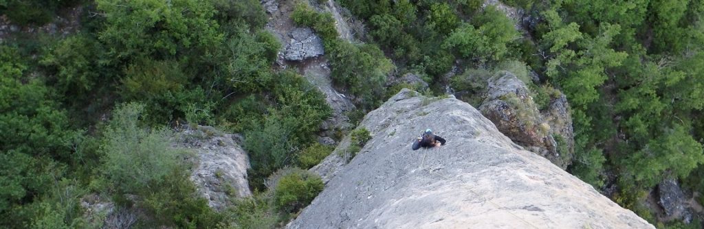 Une femme escalade une voie 6a lors d'un stage d'escalade dans les gorges de la Jonte