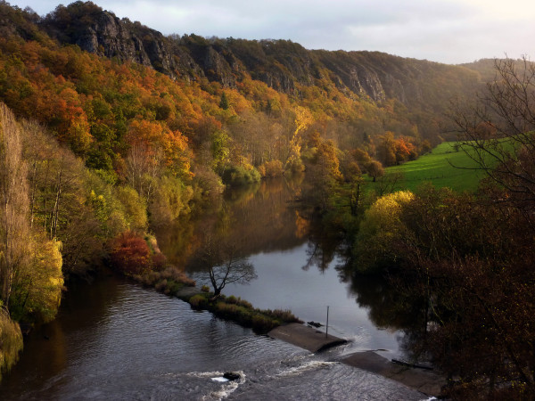 La beauté du paysage lors d'un couché de soleil sur l'Orne entourée de végétations, un environnement idéal pour un séjour d'escalade ou de randonnée